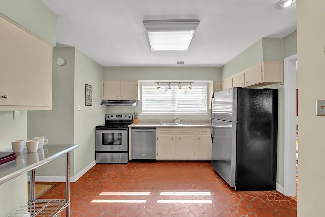 kitchen with light tile patterned floors, sink, appliances with stainless steel finishes, and cream cabinets