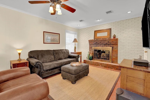 living room with ceiling fan, brick wall, a fireplace, and ornamental molding