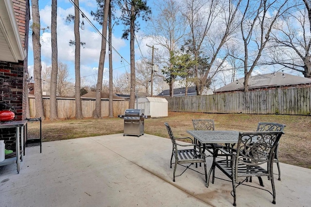 view of patio featuring area for grilling and a storage unit