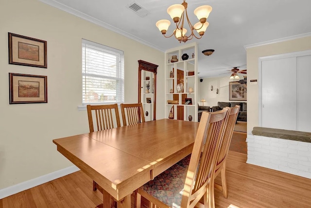 dining area featuring ceiling fan with notable chandelier, light hardwood / wood-style flooring, and ornamental molding