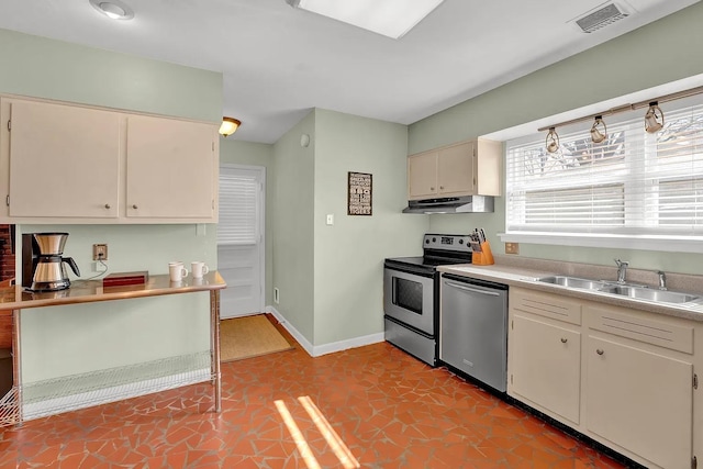 kitchen featuring sink, light tile patterned floors, stainless steel appliances, and cream cabinets