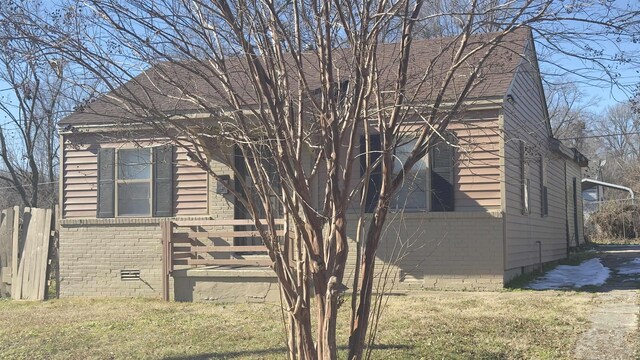 view of side of home with a yard