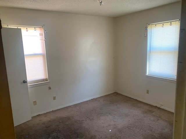 unfurnished room featuring plenty of natural light and a textured ceiling