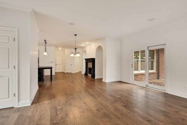 unfurnished living room featuring dark wood-type flooring and ornamental molding