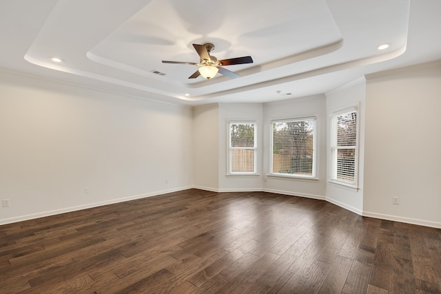 spare room with ceiling fan, dark hardwood / wood-style floors, crown molding, and a tray ceiling