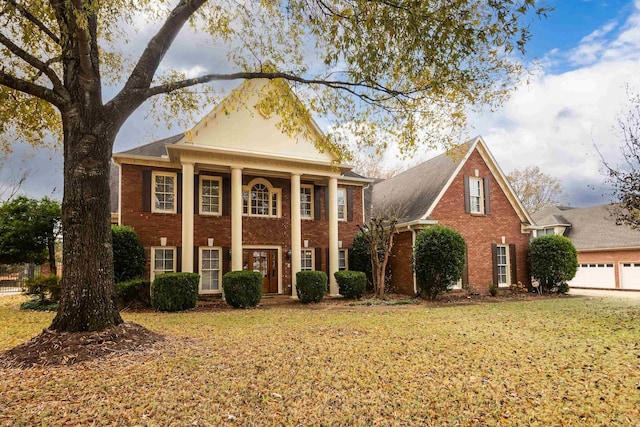 greek revival inspired property featuring a front lawn