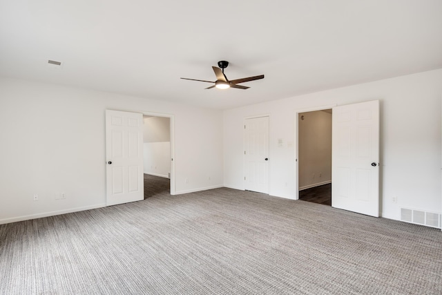 unfurnished bedroom with ceiling fan and dark carpet