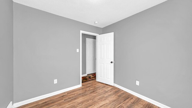 empty room with hardwood / wood-style flooring