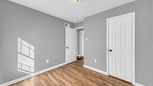 unfurnished bedroom featuring a closet and hardwood / wood-style floors