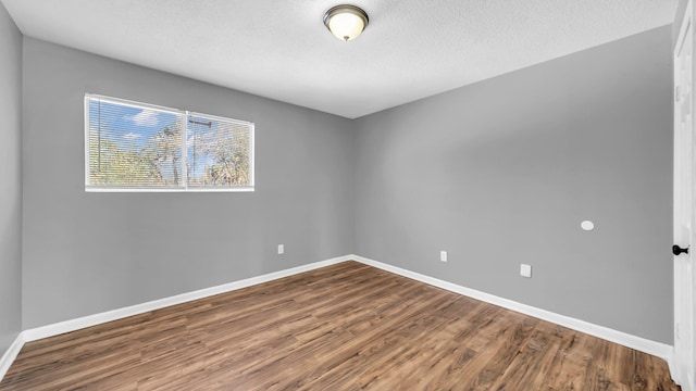 unfurnished room with a textured ceiling and hardwood / wood-style floors