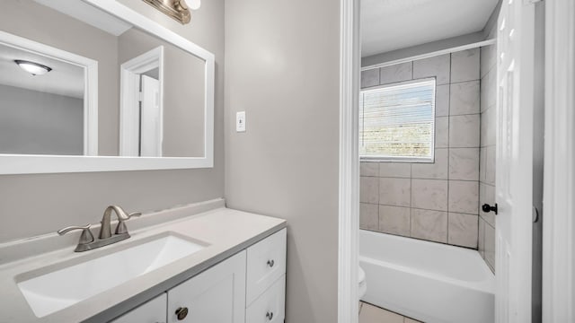 full bathroom with toilet, tiled shower / bath, and vanity