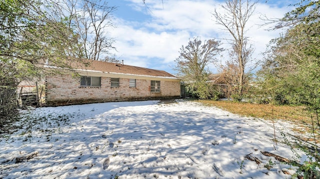 view of snow covered back of property