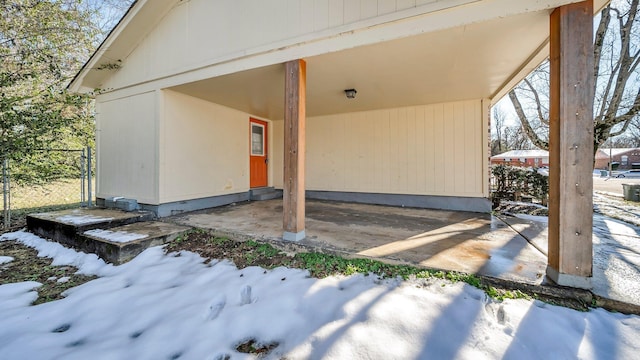 view of snow covered exterior featuring a carport