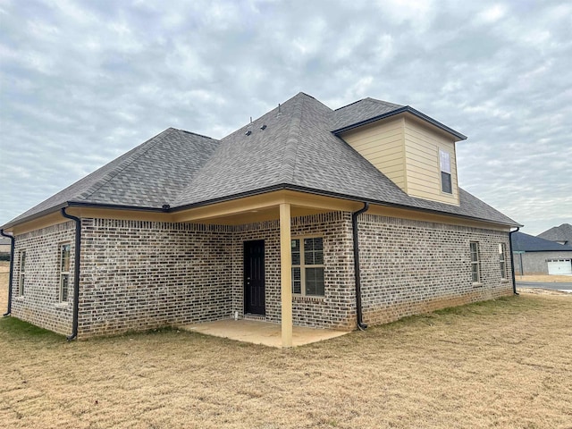 back of property with a yard and a patio