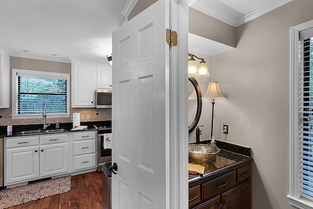 kitchen with dark wood-type flooring, white cabinetry, tasteful backsplash, sink, and ornamental molding