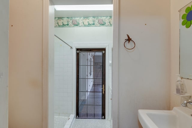 bathroom with tiled shower and sink