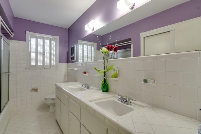 full bathroom featuring enclosed tub / shower combo, tile patterned floors, vanity, tile walls, and toilet