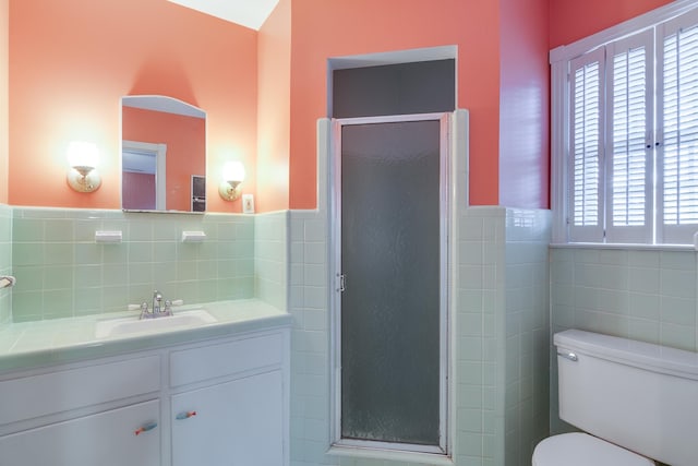 bathroom featuring tile walls, toilet, a shower with door, and a healthy amount of sunlight