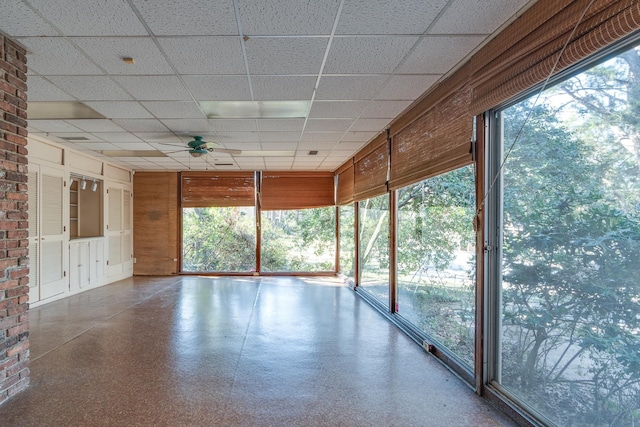 unfurnished sunroom with ceiling fan and a paneled ceiling