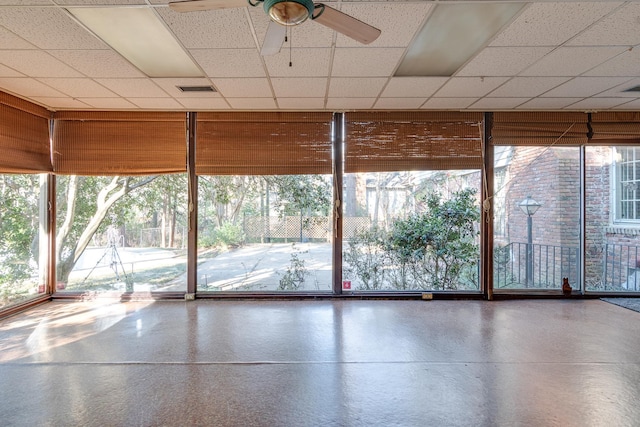 unfurnished sunroom featuring ceiling fan and plenty of natural light