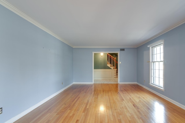 empty room with light wood-type flooring and ornamental molding