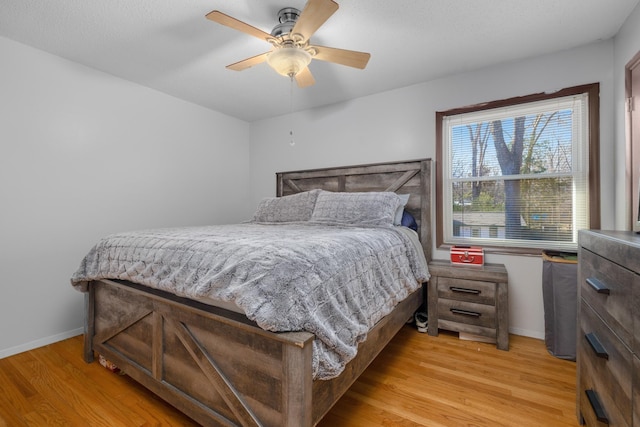 bedroom with ceiling fan and light hardwood / wood-style flooring