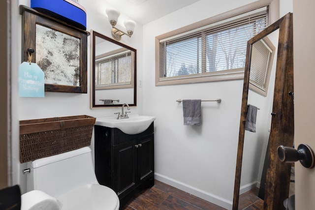 bathroom with wood-type flooring, toilet, and vanity