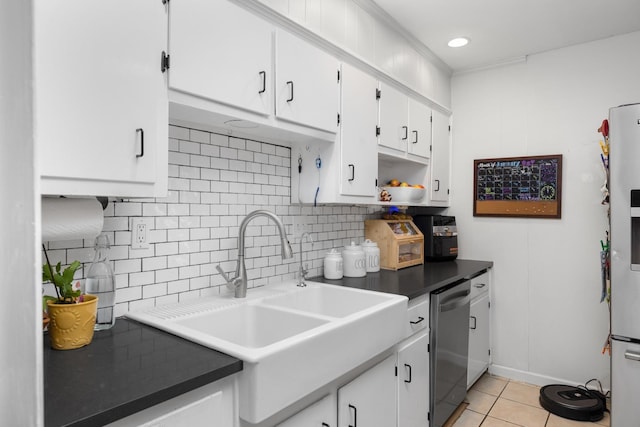 kitchen with appliances with stainless steel finishes, white cabinetry, decorative backsplash, sink, and light tile patterned flooring