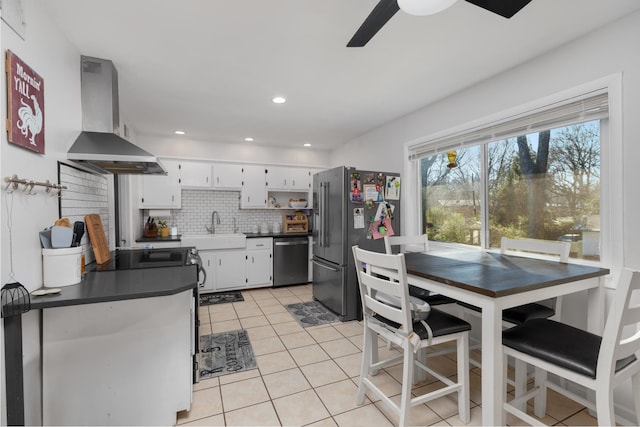 kitchen with white cabinets, appliances with stainless steel finishes, decorative backsplash, ventilation hood, and ceiling fan