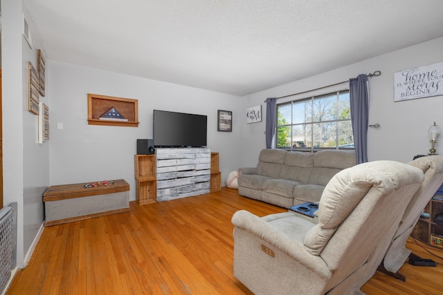 living room featuring a textured ceiling and hardwood / wood-style flooring