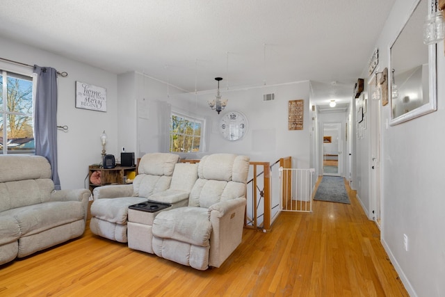 living room featuring hardwood / wood-style flooring, an inviting chandelier, and a healthy amount of sunlight