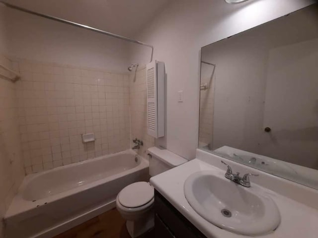 full bathroom featuring toilet, tiled shower / bath combo, and vanity