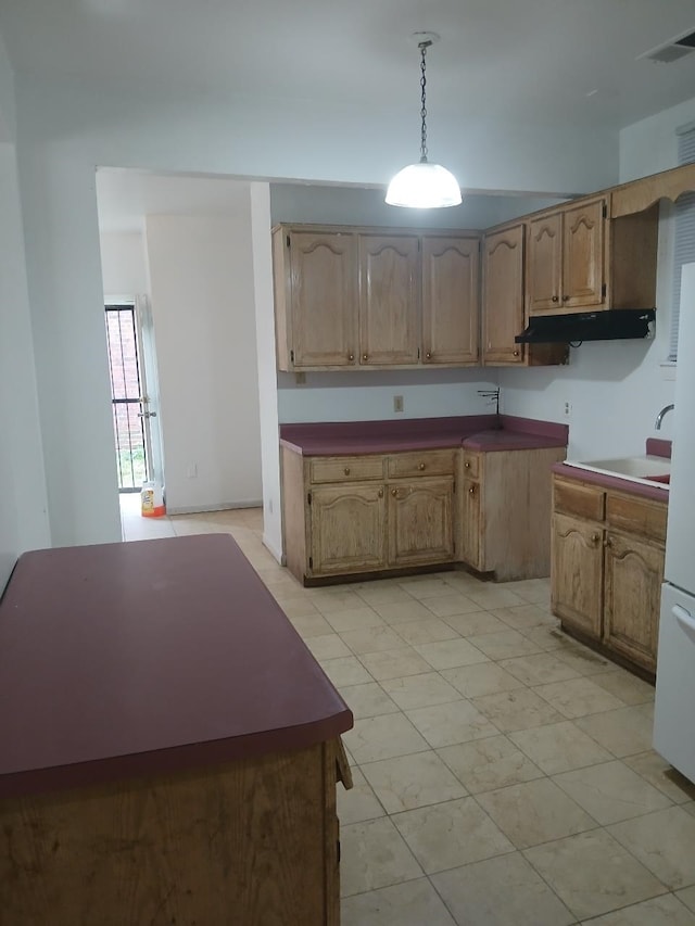 kitchen featuring white fridge, sink, and decorative light fixtures