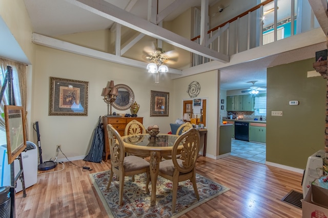 dining space featuring ceiling fan, light hardwood / wood-style flooring, and high vaulted ceiling