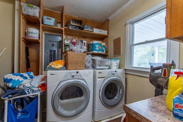 laundry room featuring a textured ceiling, ornamental molding, and washer and clothes dryer