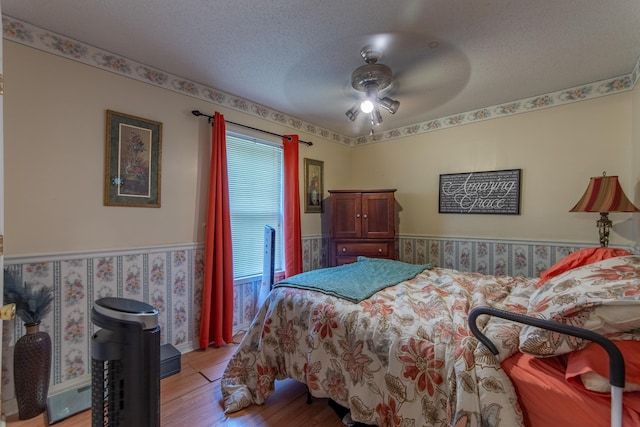 bedroom featuring a textured ceiling, ceiling fan, and light hardwood / wood-style flooring