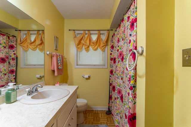 bathroom with toilet, parquet flooring, walk in shower, a textured ceiling, and vanity