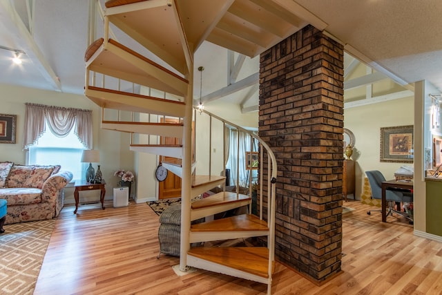 stairs featuring high vaulted ceiling, wood-type flooring, and beamed ceiling