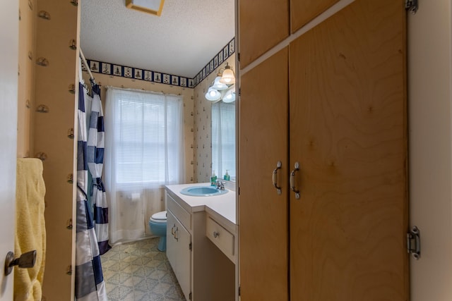 bathroom with a textured ceiling, toilet, and vanity