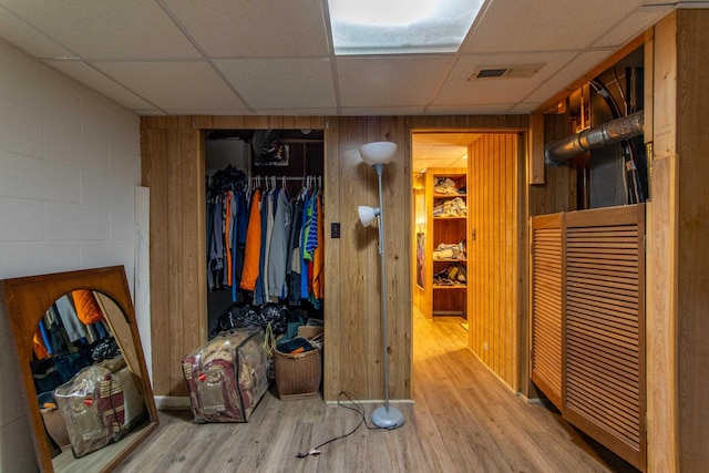 hall with hardwood / wood-style flooring and a paneled ceiling