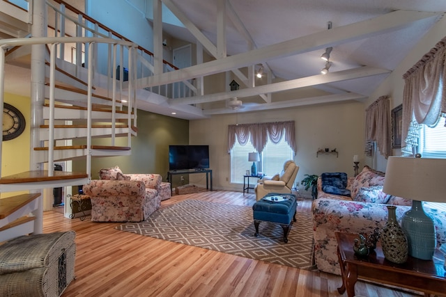 living room with hardwood / wood-style flooring, high vaulted ceiling, and beam ceiling