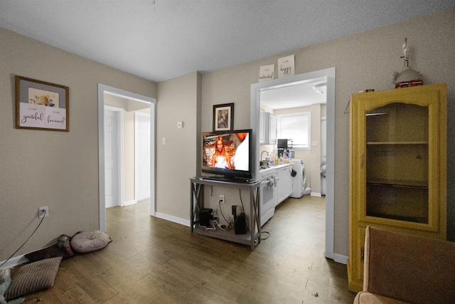 hall with washer / dryer and wood-type flooring