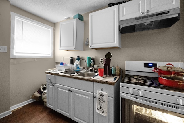 kitchen with a textured ceiling, white cabinets, dark wood-type flooring, white range with gas cooktop, and sink