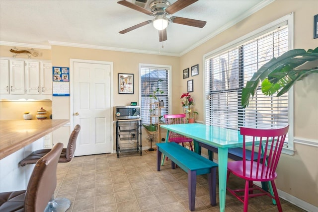 dining space featuring ceiling fan and crown molding