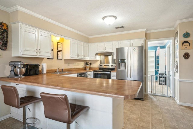 kitchen featuring white cabinets, kitchen peninsula, appliances with stainless steel finishes, and a breakfast bar area