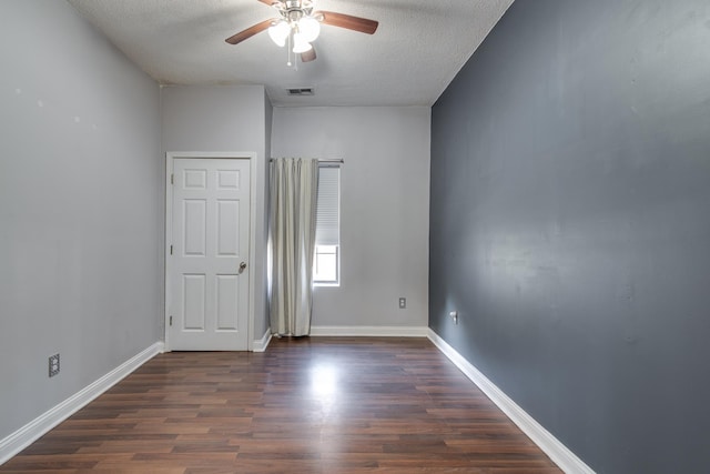 spare room with ceiling fan, dark hardwood / wood-style flooring, and a textured ceiling