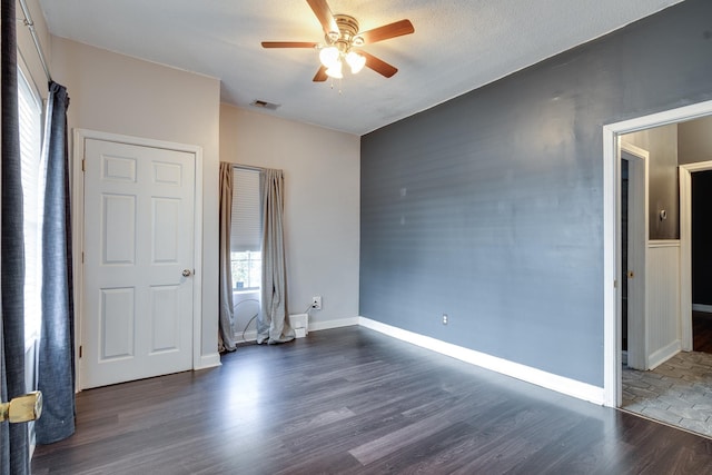 unfurnished bedroom featuring ceiling fan and dark wood-type flooring