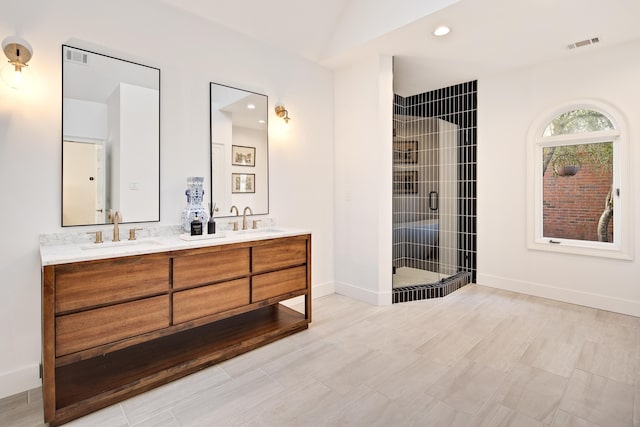 bathroom with tile patterned flooring, a shower with door, and vanity