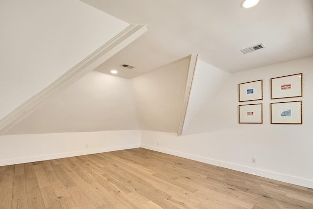 additional living space with lofted ceiling and light hardwood / wood-style flooring