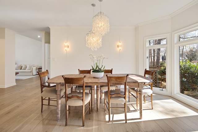 dining area featuring ornamental molding, light hardwood / wood-style flooring, and a notable chandelier